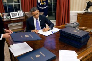 President Barack Obama signing legislation.
