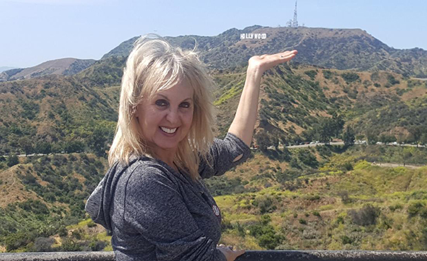 Nancy Irwin in the hills with the Hollywood sign in the distance.