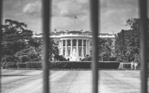 view of white house through fence.