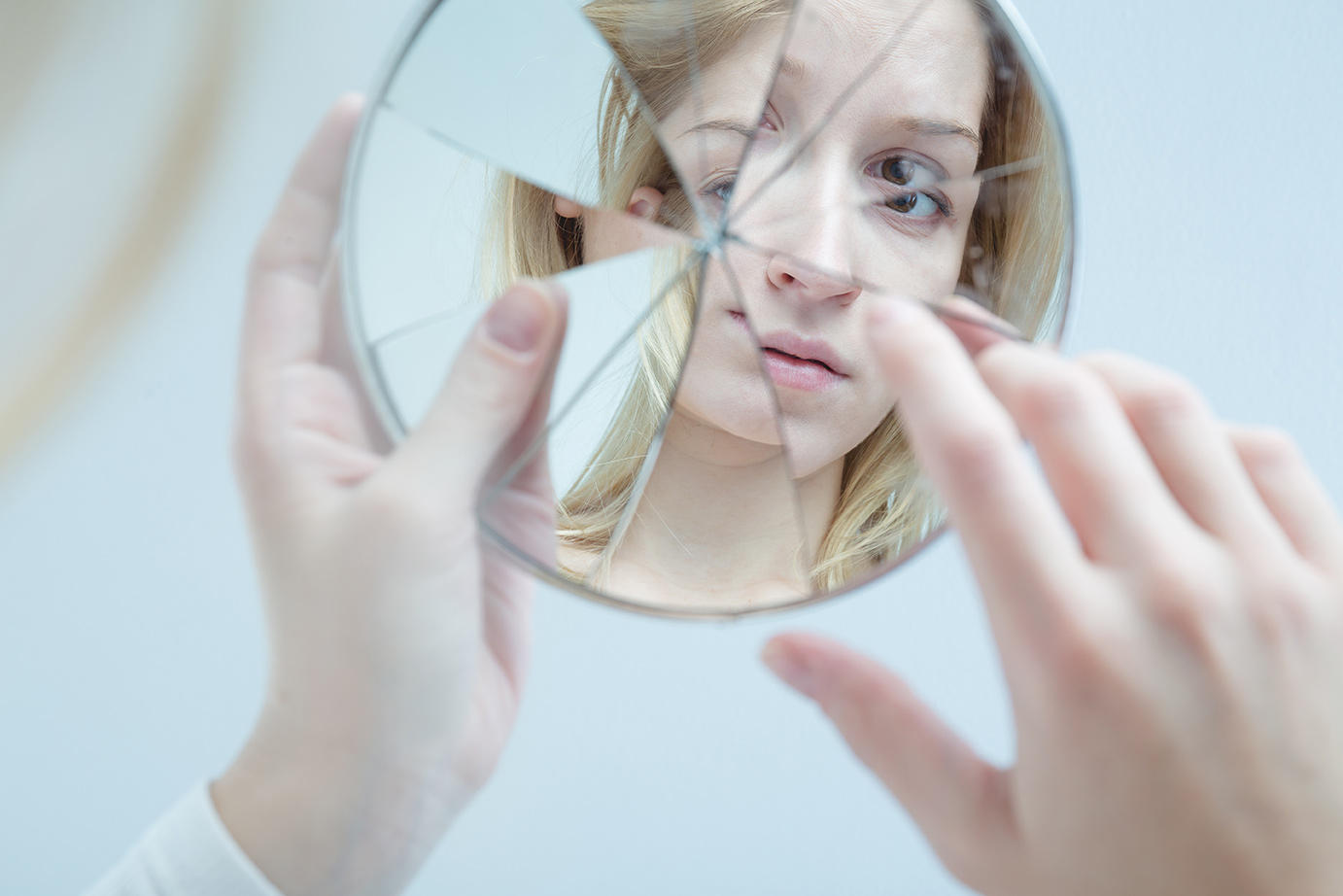 woman's reflection in a broken mirror