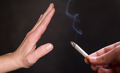 hand help up in front of cigarette, hypnosis to quit smoking, vaping or chewing tobacco, image by Tumisu from Pixabay.